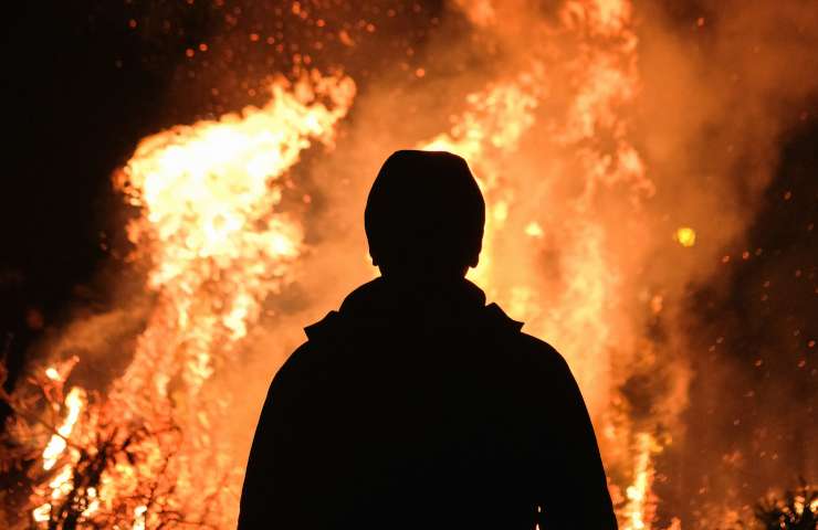 Uomo davanti a un incendio